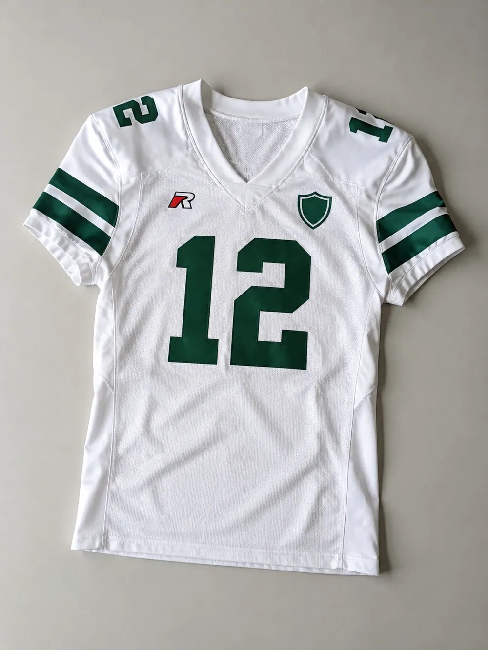 White away jersey with green sleeve stripes, flat lay