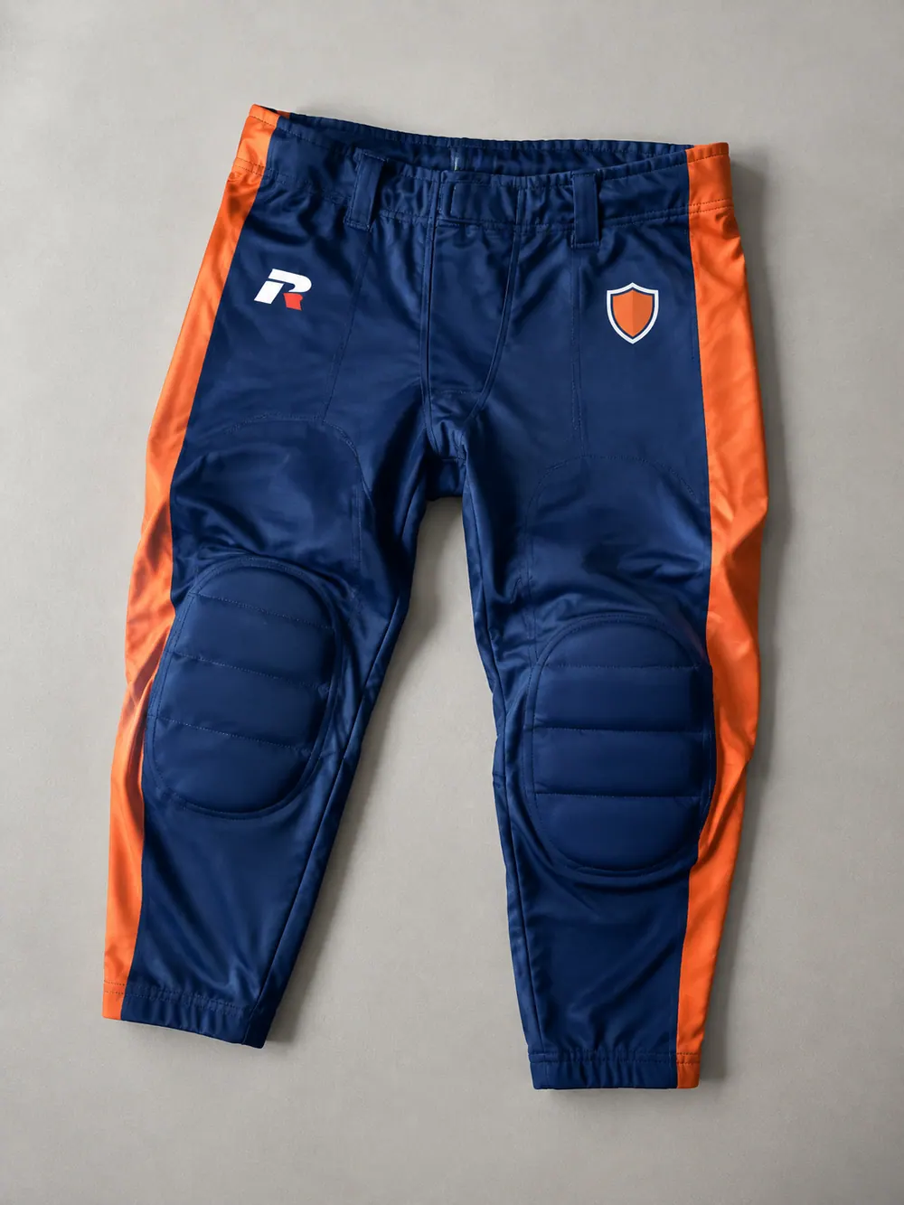 Game pants with knee-pad pockets visible, flat lay