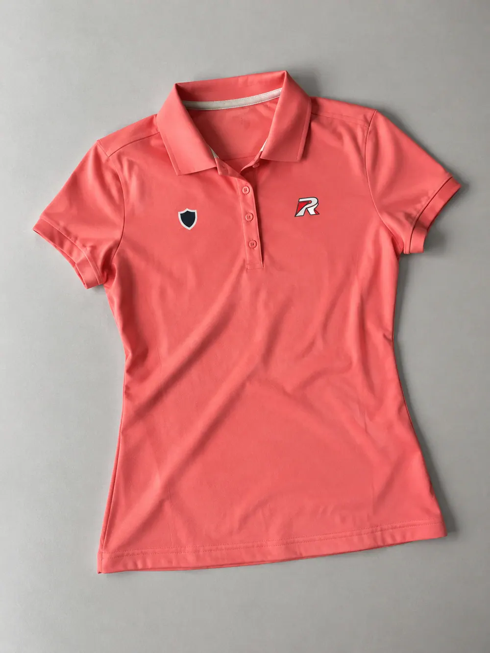 Women’s polo in coral, flat lay