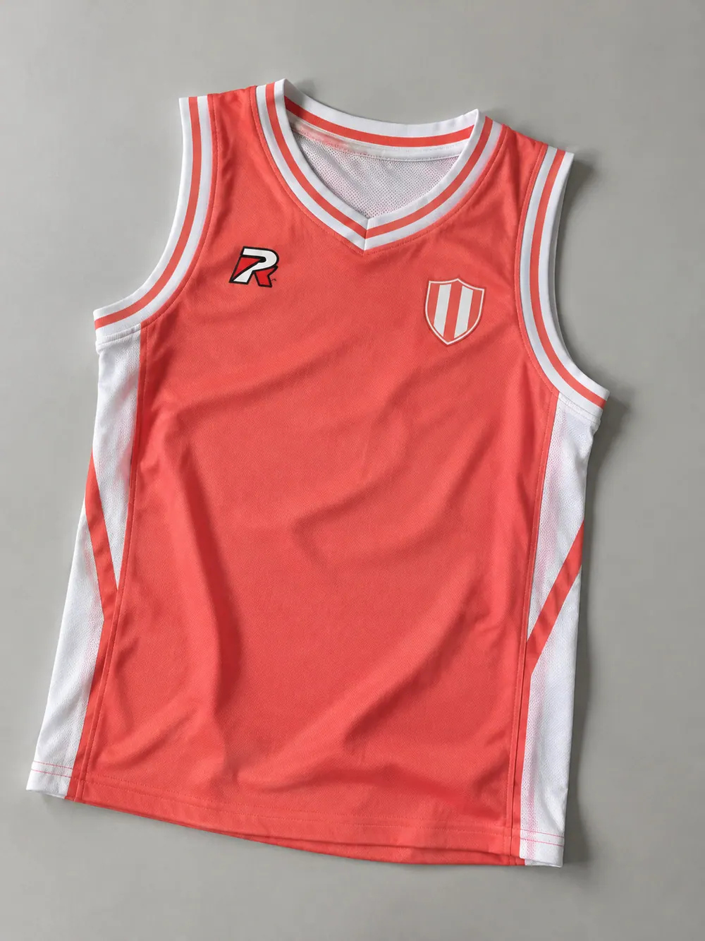 Silicone & PVC badges on a basketball singlet, flat lay